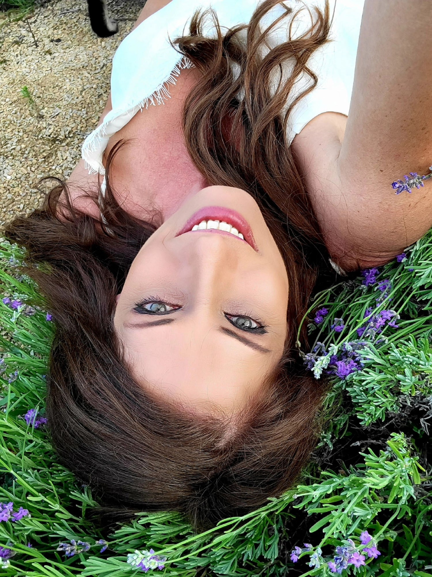 Brandy, the owner lying on grass with lavender flowers around them